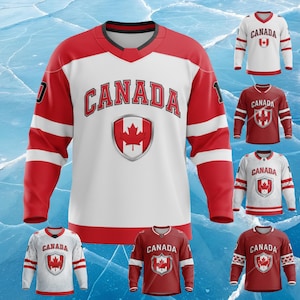 May include: A collection of Canada hockey jerseys in red and white. The jerseys feature the word "CANADA" in bold lettering and a maple leaf emblem. The jerseys have long sleeves and a v-neck design. The background is a blue and white ice texture.