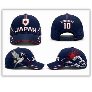 May include: Navy blue baseball cap with "JAPAN" in white lettering. The cap features a red and white design, a crane, and a rising sun graphic. The back of the cap has the text "YOUR NAME" and the number "10".