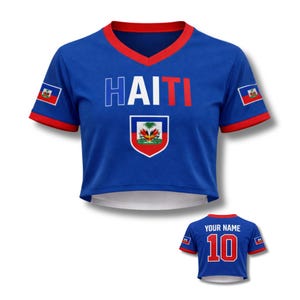 May include: Blue crop top with red trim and the word "HAITI" in white and red. Features the Haitian coat of arms and flag patches on the sleeves. A smaller version of the shirt is visible below, with the number 10 and the text "YOUR NAME".