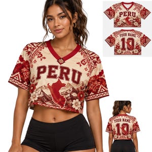 Op de afbeelding: Een crème en rode V-hals crop top met het woord PERU in vetgedrukte letters, een kaart van Peru, berglandschappen en bloemmotieven. De achterkant toont de tekst YOUR NAME boven het nummer 10, dat een kleine kaart van Peru bevat.