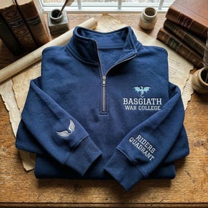 Peut inclure: Un sweat-shirt bleu marine à fermeture éclair quart de zip avec des broderies blanches. Il affiche le texte "Basgiath War College" et "Riders Quadrant", ainsi qu'un motif de dragon. Une aile est brodée sur la manche gauche.