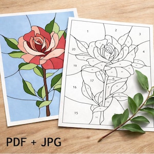 May include: Two rose-themed colouring pages. One is a completed stained-glass style rose in shades of red, pink, and green against a light blue background. The other is a line drawing of a rose with numbered sections for colouring. Text at the bottom reads "PDF + JPG".