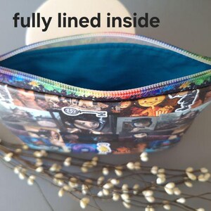 May include: A colorful zippered pouch with a blue lining. The pouch is made of fabric and has a collage of images printed on the outside. The text "fully lined inside" is visible in the image.