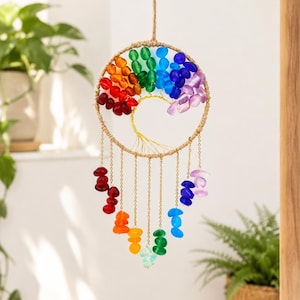 May include: A circular wall hanging featuring a wire tree of life design inside a jute-wrapped hoop. The upper section is adorned with a rainbow of colorful glass beads, while gold-toned chains hang below, each tipped with matching glass beads.