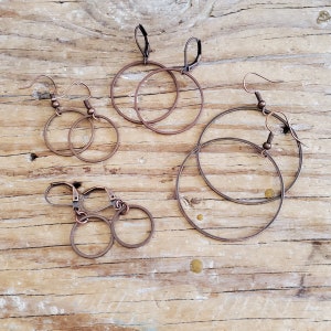 May include: Four pairs of copper hoop earrings with different sizes. The earrings have a simple design and are perfect for everyday wear.
