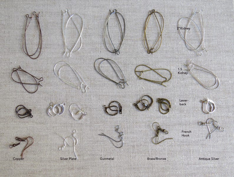 May include: A collection of various earring findings in different metal finishes, including copper, silver plate, gunmetal, brass/bronze, and antique silver. Styles include kidney, lever-back, and French hook designs. The image shows a variety of shapes and sizes.
