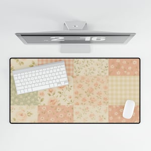 Könnte beinhalten: Ein Schreibtischunterlage mit floralem Patchwork-Design, einer weißen Tastatur und einer Maus. Die Matte zeigt Blumen- und Vichy-Muster in Rosa, Grün und Creme. Im Hintergrund ist ein Computermonitor zu sehen.
