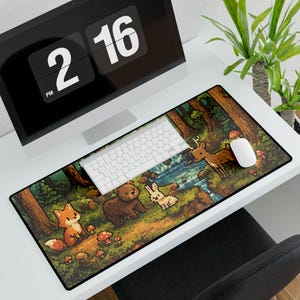 May include: A rectangular mouse pad featuring a pixelated forest scene with a fox, bear, rabbit, and deer. The pad has a black border and is placed on a white desk with a computer, keyboard, and mouse.