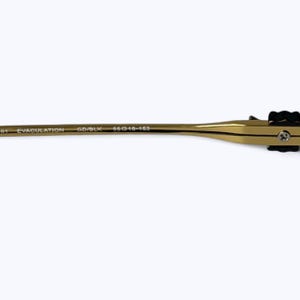 May include: Close-up of a gold-colored eyeglass frame arm with black accents. The text "EVACULATION" and "GD/BLK" are printed on the arm. The frame size is 55-18-153.