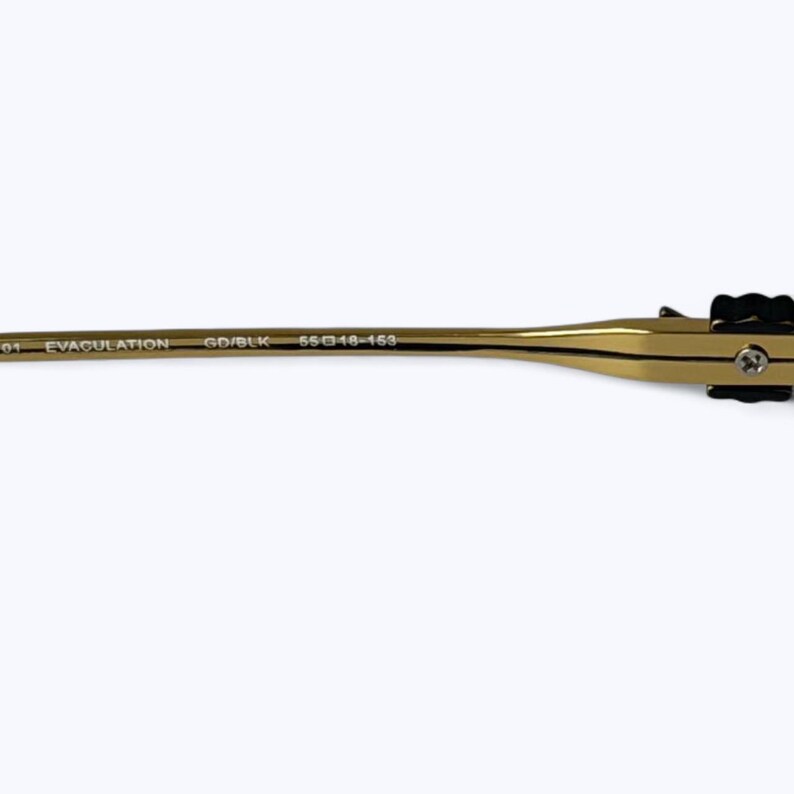 May include: Close-up of a gold-colored eyeglass frame arm with black accents. The text "EVACULATION" and "GD/BLK" are printed on the arm. The frame size is 55-18-153.
