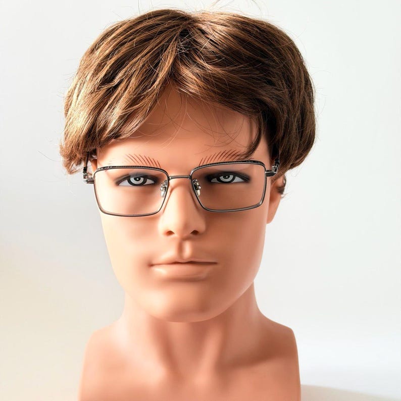 May include: Rectangular eyeglasses with a silver metal frame. The glasses are displayed on a mannequin head with brown hair. The background is plain white.