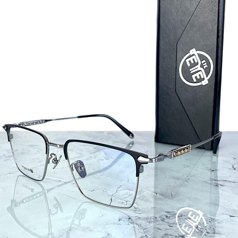 Titanium rectangular eyeglass frames in black and silver with golden temple accents. Suitable for prescription or fashion lenses. Includes hard ETE case, soft pouch, and cleaning cloth. Lightweight, durable, and hypoallergenic design for men and women. Ideal as a stylish gift with fast worldwide shipping.
