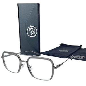 Könnte beinhalten: Brille mit anthrazitfarbenem Rahmen in quadratischer Form, mit klaren Gläsern und einem Doppelsteg. Die Brille wird von einem schwarzen Etui und zwei schwarzen Beuteln begleitet, alle mit dem weißen "EYE"-Logo.