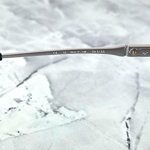 Titanium rectangular eyeglass frames in black and silver with golden temple accents. Suitable for prescription or fashion lenses. Includes hard ETE case, soft pouch, and cleaning cloth. Lightweight, durable, and hypoallergenic design for men and women. Ideal as a stylish gift with fast worldwide shipping.