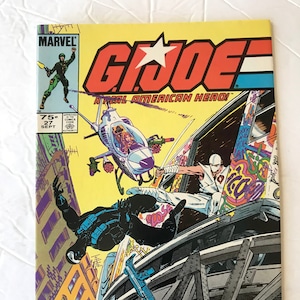 May include: A vintage G.I. Joe comic book cover with a yellow background. The cover features a helicopter, a ninja, and other action figures in a city setting. The title "G.I. Joe: A Real American Hero!" is prominently displayed, along with the Marvel logo.