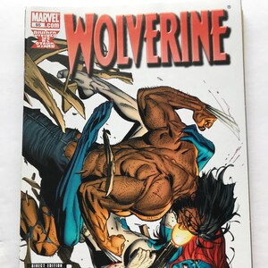 May include: Comic book cover featuring Wolverine and Mystique in a fight. Wolverine is on top of Mystique, who is on the ground. The cover is white with red and blue accents. The title "Wolverine" is in large red letters. The issue number is 65.