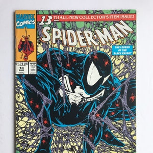 May include: A Marvel Comics Spider-Man issue 13 comic book featuring a black-suited character crouching amidst a web covered in small red spiders. The cover includes the text 13th ALL-NEW COLLECTOR'S ITEM ISSUE, SPIDER-MAN, and SUB-CITY PART ONE OF TWO.