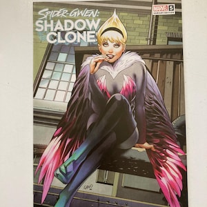 May include: A comic book cover featuring Spider-Gwen in a black and white costume with pink and green feathered wings. The cover is titled "Spider-Gwen: Shadow Clone" and has the Marvel logo and the number 5.