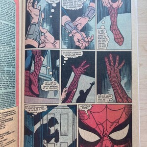 May include: A comic book page featuring Spider-Man in a red and blue costume. Panels show close-ups of web-shooters, hands pulling on a red webbed glove, and a silhouette of a figure standing in a doorway. Text bubbles include dialogue about web fluid.