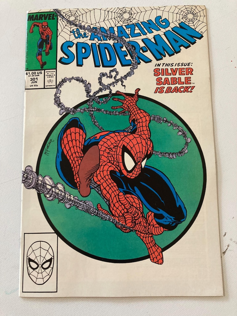 Pu&ograve; includere: Una copertina di fumetto vintage di The Amazing Spider-Man. La copertina presenta Spider-Man in una posa dinamica, con il titolo in blu e bianco. Il numero dell'edizione &egrave; il 301 e il testo "Silver Sable is Back!" &egrave; visibile.
