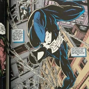May include: A comic book panel illustration featuring a character in a black suit with a white spider emblem, swinging through a city on silver chains. The character is depicted in a dynamic pose above buildings, surrounded by several text boxes.