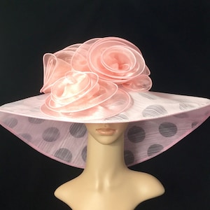 May include: A pink and white polka dot hat with a large pink flower on top.