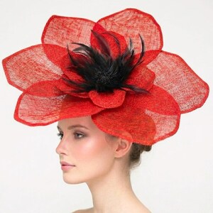 May include: A vibrant red floral hat with a layered petal design. The hat features a cluster of black feathers at the center, adding a touch of elegance. This statement headpiece is perfect for special occasions.