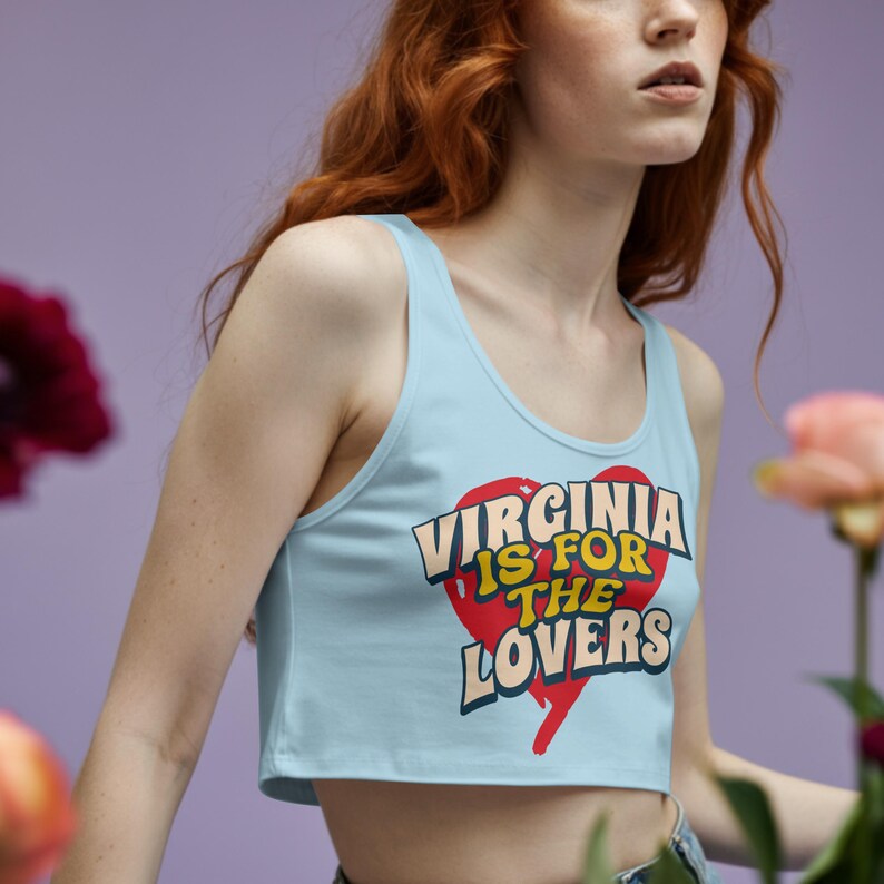 May include: Light blue crop top with the text "VIRGINIA IS FOR THE LOVERS" in a heart-shaped design. The text is in white, yellow, and blue. The top is sleeveless and has a scoop neck.
