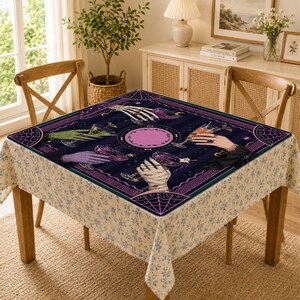 May include: A square tablecloth featuring a dark purple and black striped background with a central pink circle. The design displays four distinct hands, including a skeleton hand and a mummy hand, each holding a glass with a different colored liquid.
