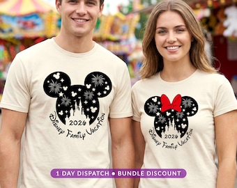 May include: Two cream-colored t-shirts featuring a black Mickey Mouse head silhouette graphic. The design includes a castle, fireworks, stars, and the text "Disney Family Vacation 2026". One shirt includes a red bow on the Mickey head silhouette.