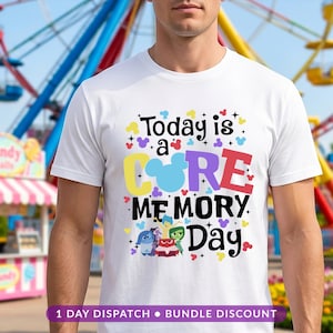 May include: A white short-sleeved t-shirt featuring a colourful graphic print that reads Today is a CORE MEMORY Day. The design includes small mouse-ear silhouettes, stars, and illustrations of five animated characters in blue, yellow, red, and green.