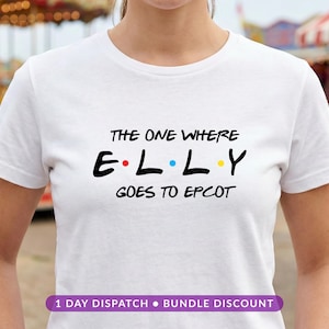 May include: A white short-sleeved t-shirt featuring black text that reads THE ONE WHERE E L L Y GOES TO EPCOT. The letters E, L, L, and Y are separated by small red, blue, and yellow dots, mimicking a classic television show logo style.