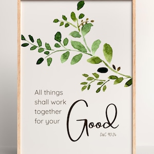 May include: A framed print with a light wood frame. The print features a watercolor-style green leafy branch in the upper left corner. The text reads "All things shall work together for your Good" with the scripture reference D&C 90:24.