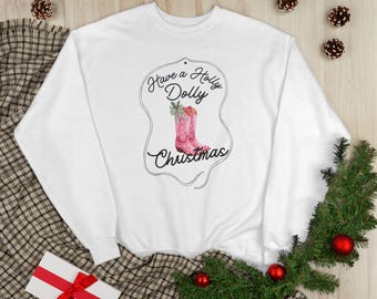 May include: White crewneck sweatshirt with the text "Have a Holly Dolly Christmas" in black script. The design features a pink cowboy boot with a green bow. The sweatshirt is surrounded by pinecones, red ornaments, and greenery.