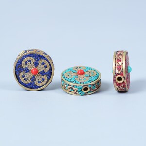 K&ouml;nnte beinhalten: Drei dekorative, runde Boxen mit aufwendigen Designs. Eine Box ist blau mit roter Mitte, eine weitere t&uuml;rkis mit roter Mitte, und die dritte ist rot mit t&uuml;rkisfarbenem Akzent. Die Boxen haben eine goldfarbene Metallverkleidung.