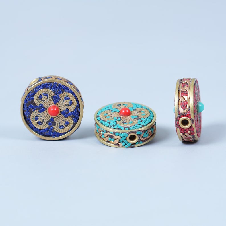 K&ouml;nnte beinhalten: Drei dekorative, runde Boxen mit aufwendigen Designs. Eine Box ist blau mit roter Mitte, eine weitere t&uuml;rkis mit roter Mitte, und die dritte ist rot mit t&uuml;rkisfarbenem Akzent. Die Boxen haben eine goldfarbene Metallverkleidung.