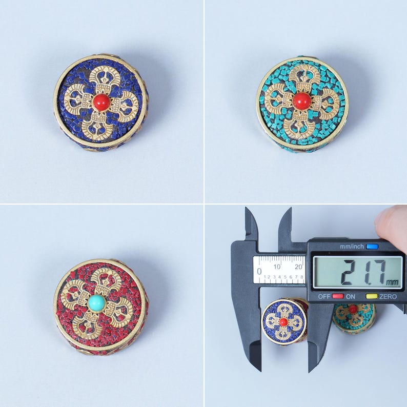 K&ouml;nnte beinhalten: Drei runde, dekorative Objekte mit aufwendigen Designs. Jedes St&uuml;ck hat einen zentralen Edelstein und ein Mosaik aus farbigen Steinen, eingebettet in einen goldfarbenen Metallrahmen. Das digitale Messschieber zeigt eine Messung von 21,7 mm.