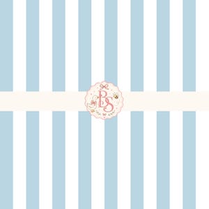 May include: A pattern of vertical light blue and white stripes featuring a central scalloped circular emblem. The emblem displays the pink letters BS, a small duck with a pink bow, a bee, and decorative floral elements on a cream background.