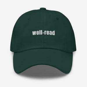 May include: A dark green baseball cap with the text "well-read" embroidered in white across the front. The cap has a curved peak and a button on top.