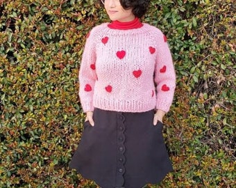 Pull en tricot chunky rose avec coeurs rouges