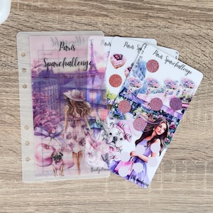 May include: A collection of planner accessories featuring illustrations of Paris. The designs include a woman with a pug, the Eiffel Tower, and various decorative elements. The text "Paris Sparchallenge" is visible on the items.