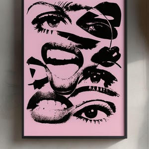 以下が含まれることがあります： ピンク色の背景に、目、唇、さくらんぼをコラージュした白黒のポップアートプリント。アートワークは黒いフレームで額装されており、印象的なコントラストを生み出しています。