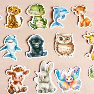 K&ouml;nnte beinhalten: Eine Sammlung farbenfroher Tieraufkleber, darunter ein Gepard, ein Krokodil, ein Delfin, eine Giraffe und eine Eule. Die Aufkleber sind im Aquarellstil mit wei&szlig;em Rand gehalten und eignen sich perfekt zum Scrapbooking oder Dekorieren.