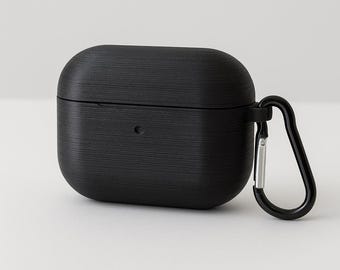 May include: A black textured case for wireless earbuds with a matching black carabiner clip. The case has a matte finish and a small circular opening for charging. The carabiner is silver.