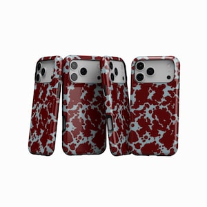 May include: Four smartphone cases with a maroon and pale blue splatter design. The cases are displayed from various angles, highlighting the pattern on the front and sides. They have a glossy finish and are designed for a smartphone.