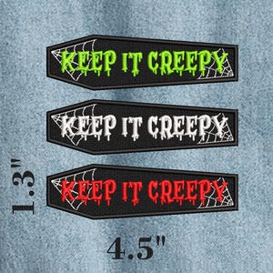 Op de afbeelding: Drie doodskistvormige geborduurde patches van 3,3 cm bij 11,4 cm. Elke zwarte patch heeft een wit spinnenwebontwerp en de tekst "KEEP IT CREEPY" in limoengroen, wit en rood garen in een druipende letterstijl.