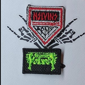 Może przedstawiać: Dwie haftowane naszywki. G&oacute;rna naszywka ma kształt czerwonej, białej i czarnej tarczy z napisami "MELVINS" i "ARMY". Dolna naszywka to czarny prostokąt z zielonym tekstem. Tło przedstawia gest szkieletowej dłoni.