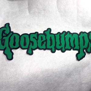 May include: Green "Goosebumps" logo with a black outline. The text is in a stylized, dripping font, evoking a sense of horror and suspense. The logo is set against a white background.