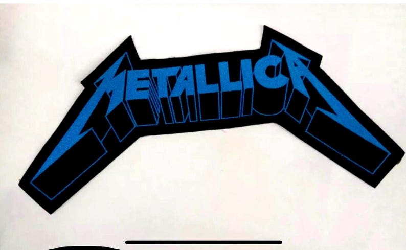 May include: A black and blue embroidered patch with the word "METALLICA" in a stylized font.