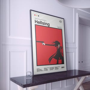 May include: Framed poster featuring the anime "Hellsing." The poster has a red background with a black silhouette of a character holding a gun. The title "Hellsing" is displayed in white, along with the year 2001. The poster is displayed on a dark table.